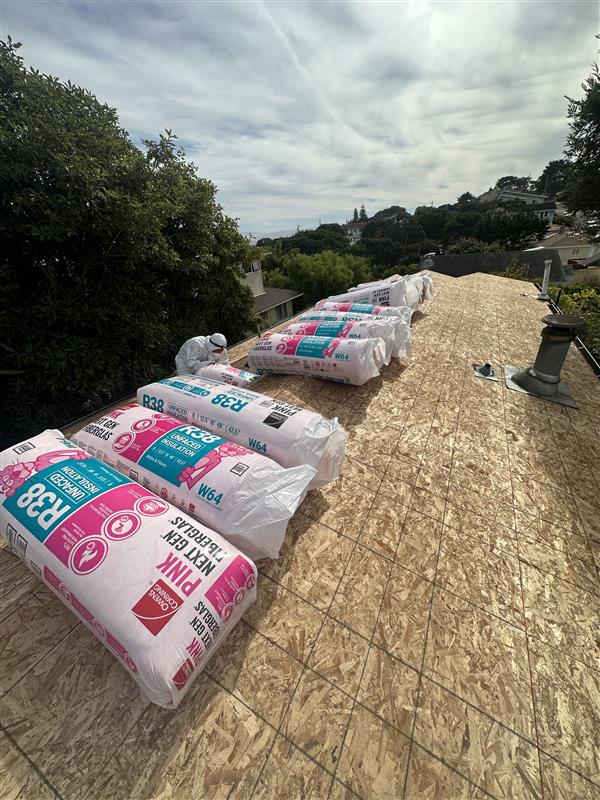 Roofer completing roof repair near damaged flashing on a residential roof slope